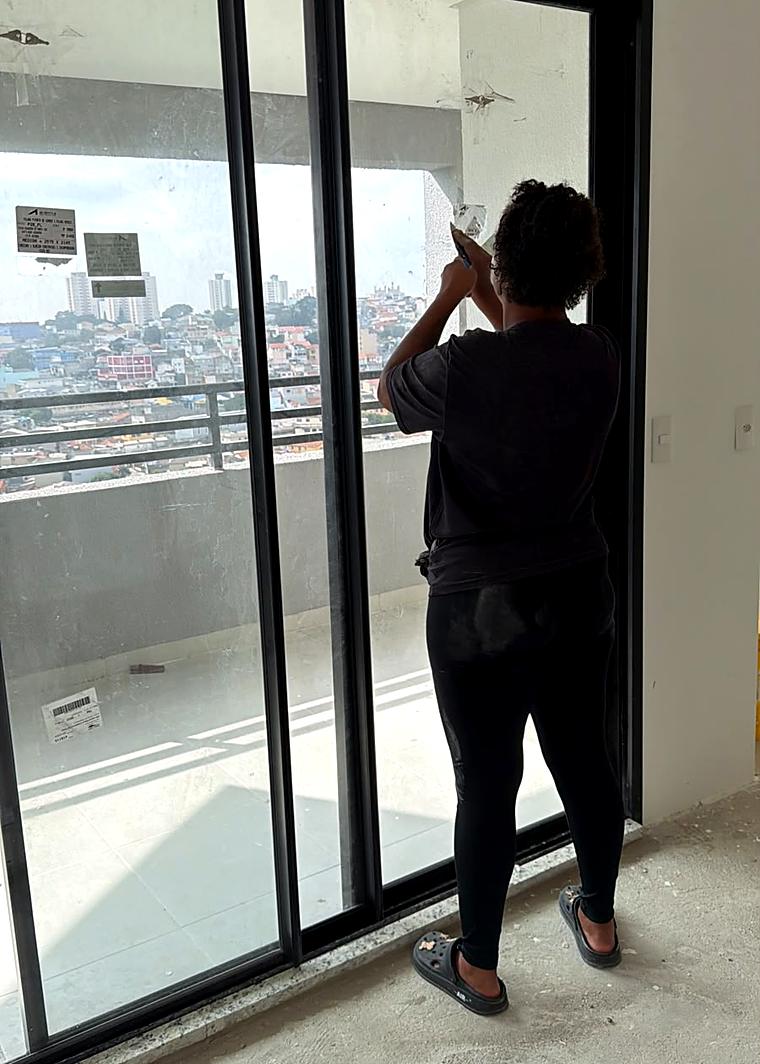 Profissional da Hello limpando vidro de fachada em prédio corporativo